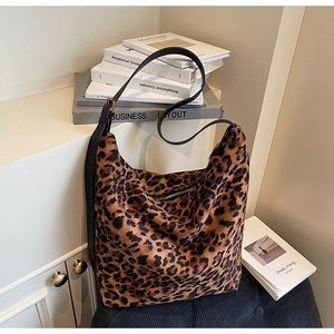 Detailed view of leopard print bucket bag with leather strap on a stylish home background