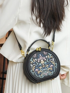 Elegant black round crossbody bag with colorful floral embroidery and gold metal zipper