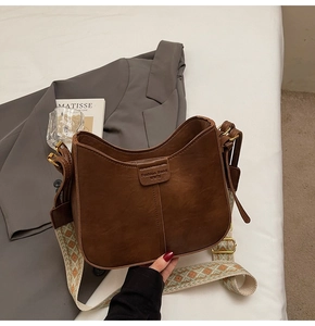 Détail du sac lune marron caramel avec bandoulière jacquard et gaufrage tendance