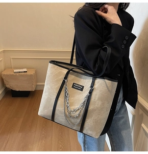 Détail du sac cabas en toile avec triples chaînes en métal argenté et cuir noir