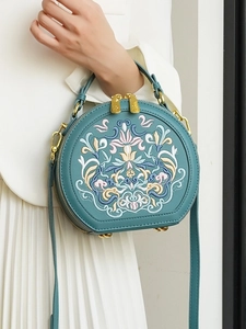 Dark green semi-round crossbody bag with intricate traditional floral embroidery and gold hardware