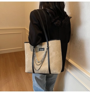 Vue détaillée d'un grand sac cabas beige avec chaînes argentées et bordures en cuir noir