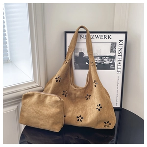 Détail du cabas hobo en daim camel avec motifs floraux ajourés et pochette assortie