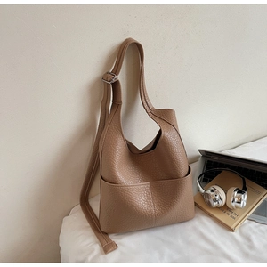 Close-up of brown lychee grain leather hobo bag with adjustable strap and front pocket