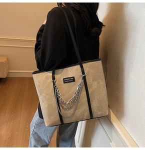 Vue détaillée du grand sac cabas en daim kaki avec chaînes argentées et bords noirs