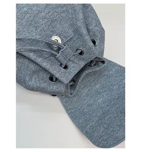 Close-up of denim backpack featuring drawstring closure and metallic eyelets detail
