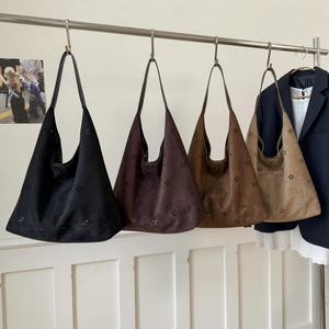 Detail view of large faux suede hobo tote bags with laser-cut flower patterns in four colors