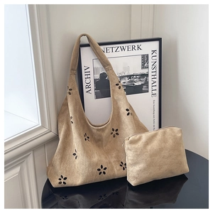 Détail du sac cabas en daim camel avec découpes florales et pochette assortie