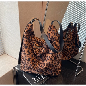 Close-up of leopard print canvas bucket bag featuring premium leather strap and zipper