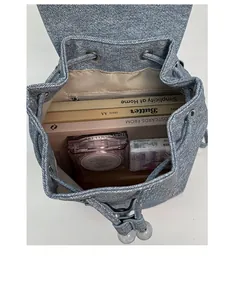 Top view of blue denim backpack interior showing drawstring closure and inner zipper pocket