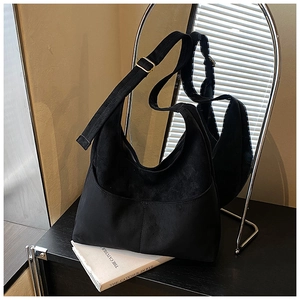 Dettaglio della borsa hobo in camoscio nero opaco con fibbia dorata e cuciture a vista