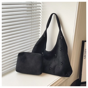 Détail du sac cabas en daim noir avec motifs floraux découpés au laser et pochette