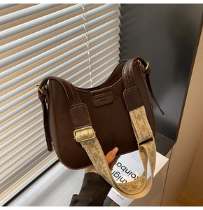 Détail du sac vintage en cuir marron avec bandoulière brodée au motif géométrique