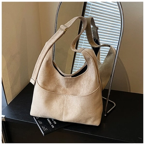 Dettaglio della borsa tote beige in finto camoscio con tracolla e fibbia in metallo dorato