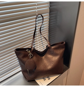 Close-up of dark brown faux leather tote bag with fine grain texture and matching pouch
