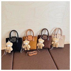 Detail view of four matte retro bucket bags with teddy bear charms and straps