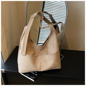 Dettaglio della borsa hobo in pelle scamosciata beige con cuciture e fibbia dorata