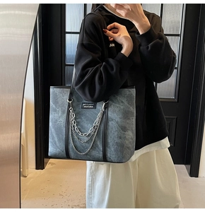 Détail du grand sac cabas gris mat avec triple chaînes en métal et fines anses noires