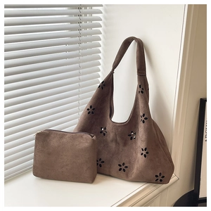 Détail d'un ensemble cabas vintage marron dépoli avec découpes fleurs et pochette