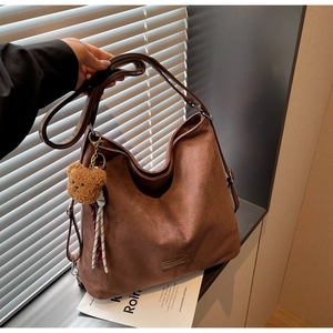Detailansicht der großen dunkelbraunen Wildleder-Tote-Bag mit süßem Plüschbär-Anhänger