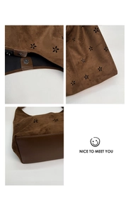 Detail view of brown suede tote with laser-cut floral patterns and magnetic closure