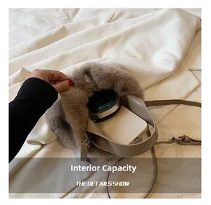 Gros plan de l'intérieur du sac seau en peluche montrant la capacité du téléphone et du maquillage