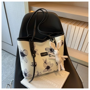 Dettaglio della borsa tote in tela con stampe floreali e ciondolo a forma di coniglio