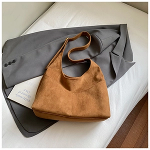 Dettaglio della borsa tote in pelle scamosciata marrone con cuciture e tracolla regolabile
