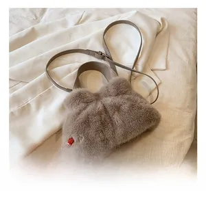 Détail de la texture en fausse fourrure et de la bandoulière en cuir de ce sac marron