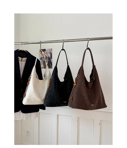 Detailed view of bucket bags with beaded leather tassels and textured finish