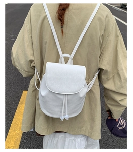 Detail of white textured leather backpack with pearl drawstring on a female model