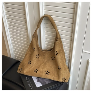 Détails du sac cabas en daim marron avec motifs floraux découpés au laser et surpiqûres