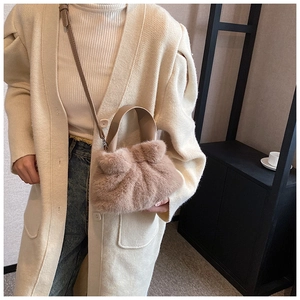 Détail du sac seau en fausse fourrure avec large poignée en cuir et bandoulière fine