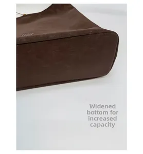 Detail view of the widened bottom design for increased storage on the brown leather tote bag