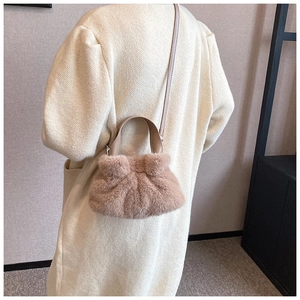 Vue détaillée du sac seau en peluche rose brun porté par un mannequin en manteau