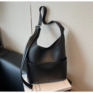 Detail of black lychee grain leather hobo bag with adjustable shoulder strap and silver buckle