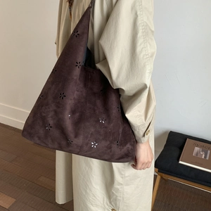 Detailed close-up of dark brown suede tote bag featuring laser-cut floral patterns