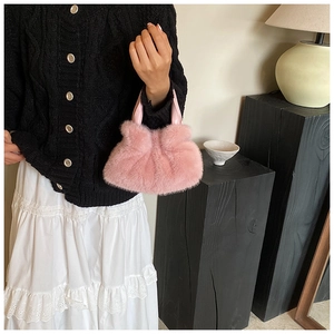 Gros plan du sac seau rose en fausse fourrure pelucheuse avec poignée en cuir sur mannequin