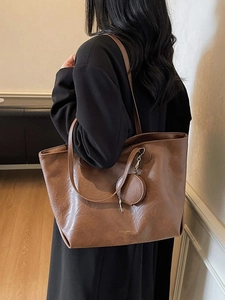 Brown large capacity leather tote bag with round coin purse shown on female model