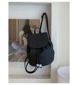 Detail of black drawstring backpack with marble beads and minimalist adjustable strap