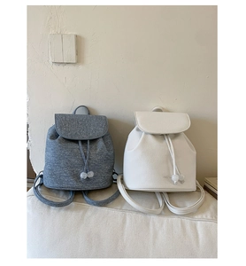Detail view of gray knit and white pebble leather mini backpacks with drawstring closure