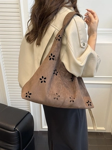 Grand sac cabas marron mat avec motifs floraux découpés au laser portés par un mannequin