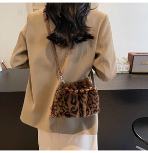 Leoparden-Fellimitat Eimertasche schräg getragen über beige Sakko für den Herbst