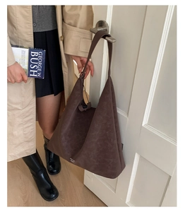 Detail of a large vintage brown shoulder bag showing matte leather texture and branding