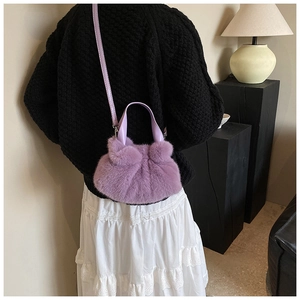 Vue détaillée du sac seau en fausse fourrure violette porté en bandoulière avec sangle