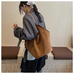 Brown frosted large bucket tote bag worn over shoulder for commuting and leisure style