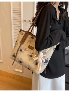 Grande borsa tote in tela con stampa floreale e ciondolo a coniglio su un modello