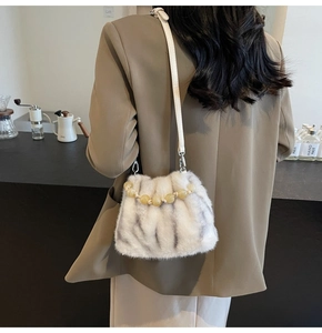 Details einer Kunstpelz-Tasche mit Perlenhenkel und Leder-Schultergurt im Leopard-Look