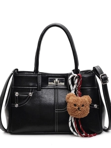 Vintage black crossbody bag with white stitching, silver twist lock and bear charm