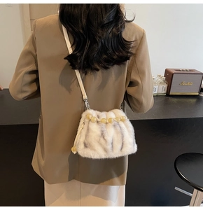 Umhängetasche aus Kunstpelz mit Perlengriff, kombiniert mit einem braunen Blazer im Vintage-Stil